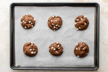 6 baked chocolate cake mix cookies on a baking sheet.