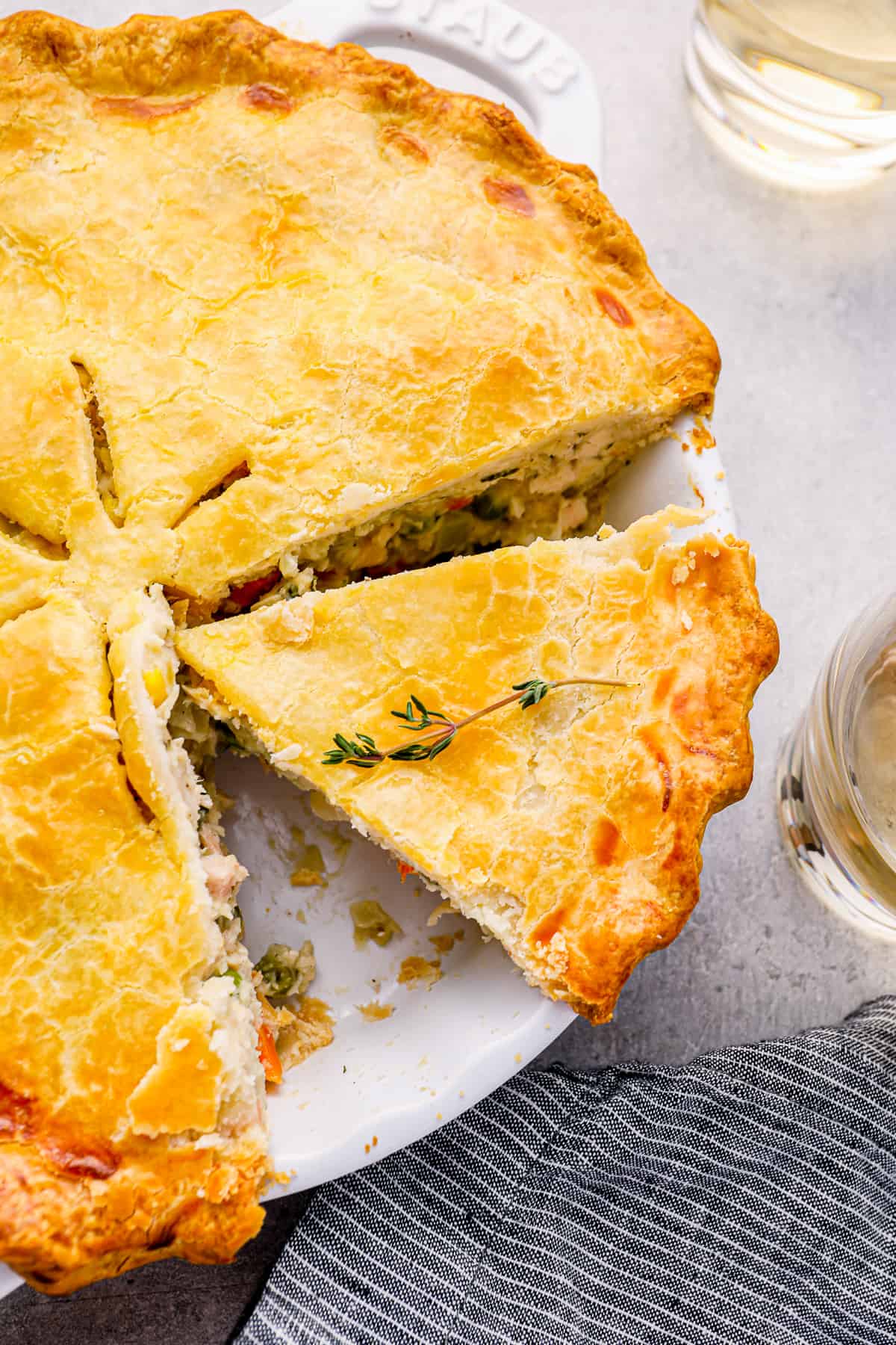 sliced chicken pot pie in a white pie pan.