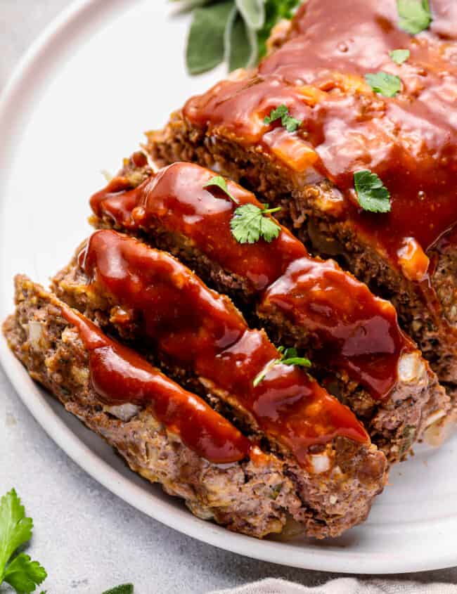 sliced instant pot meatloaf on a white serving plate.