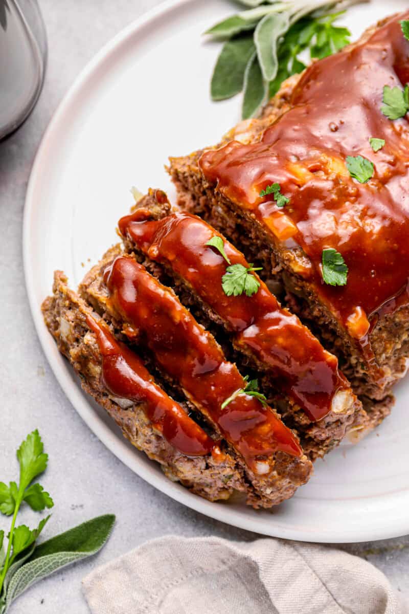 sliced instant pot meatloaf on a white serving plate.