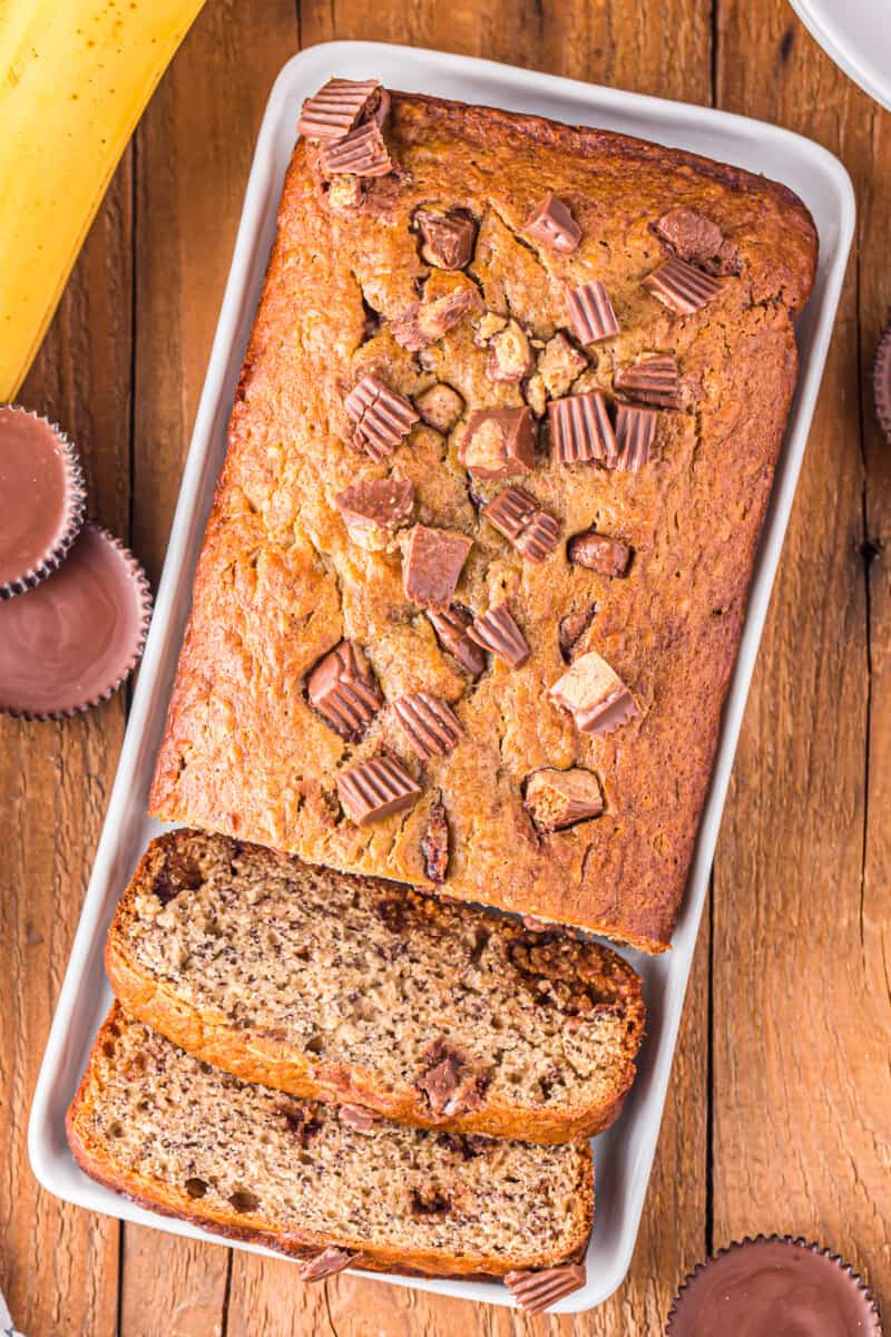 overhead view of sliced reeses peanut butter cup banana bread on a white plate.