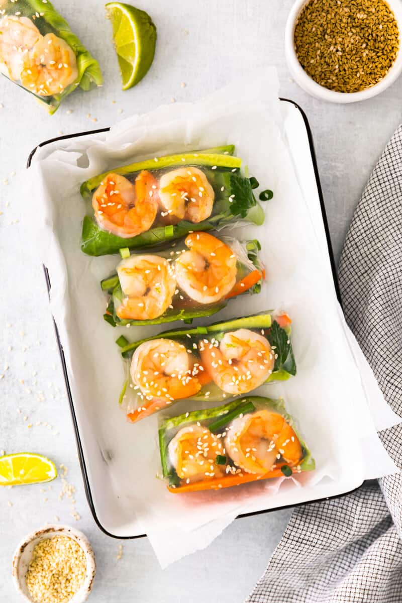 4 shrimp summer rolls in a white rectangular tray.