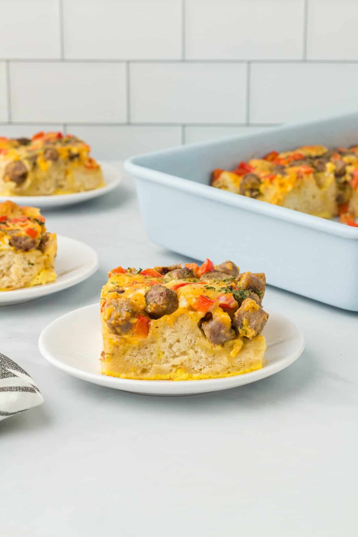 a slice of biscuit breakfast casserole on a white plate.