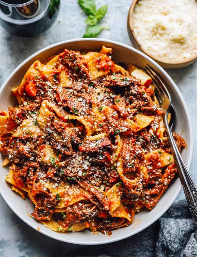 beef ragu in a white bowl with a fork.