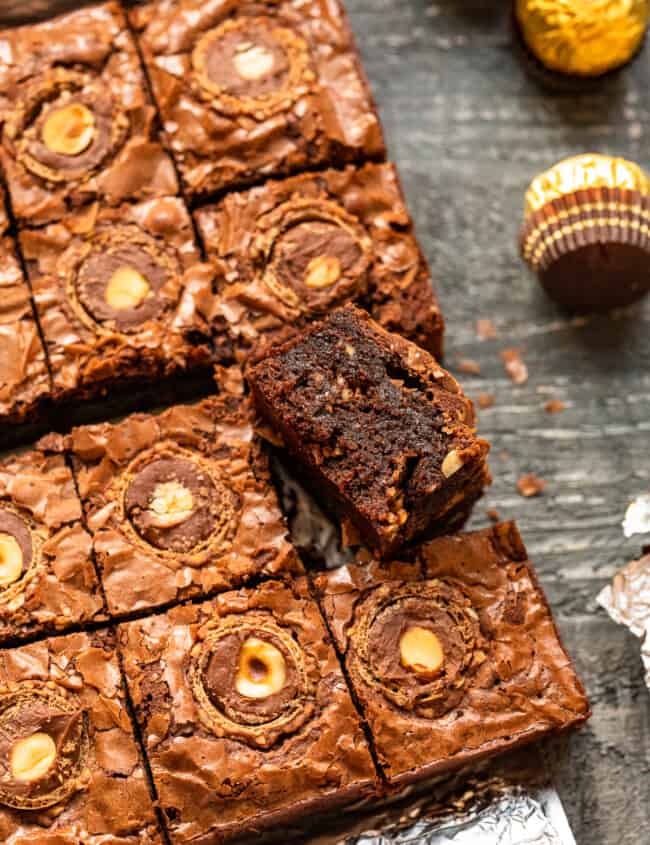 upturned ferrero rocher brownie leaning against cut ferrero rocher brownies.