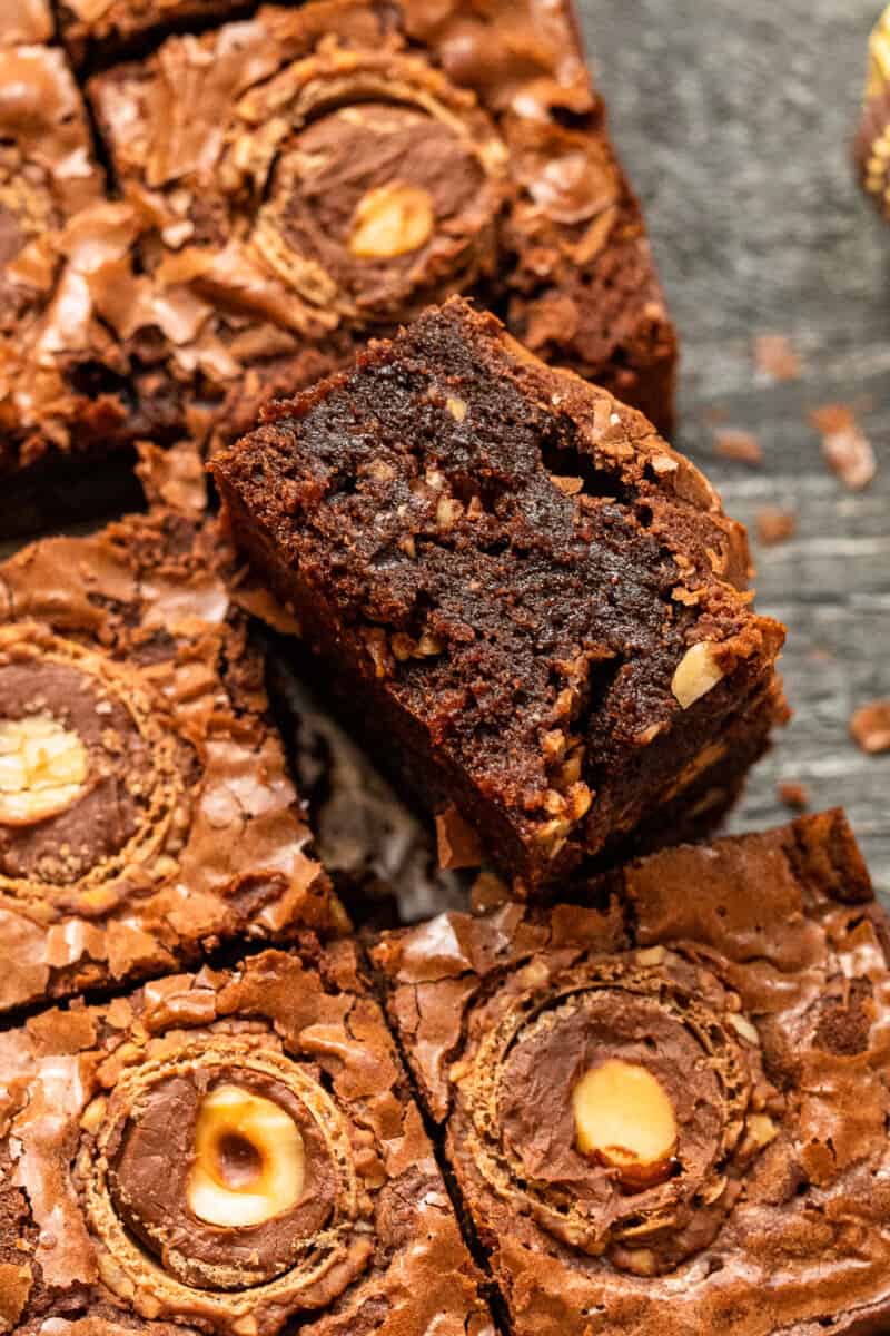 upturned ferrero rocher brownie leaning against cut ferrero rocher brownies.