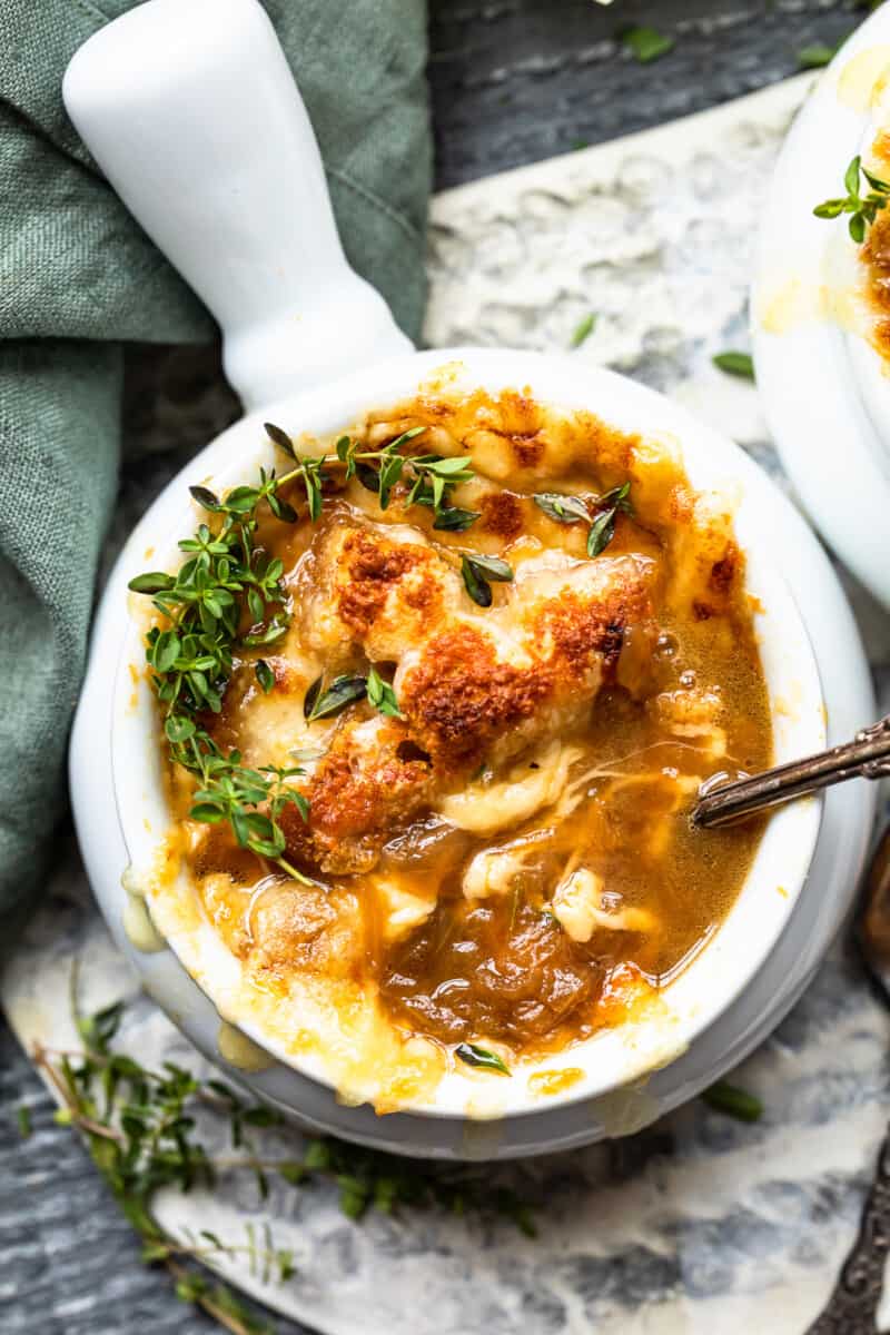 overhead view of french onion soup in a white bowl with a spoon.