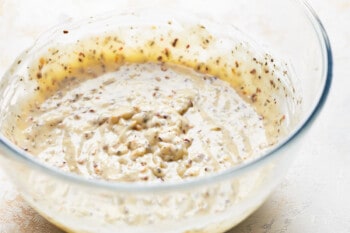 a glass bowl filled with garlic parmesan wing sauce