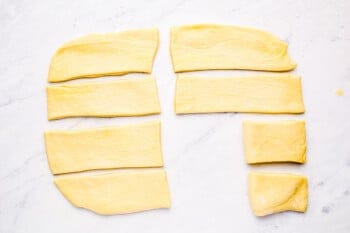 parker house roll dough strips being folded in half.