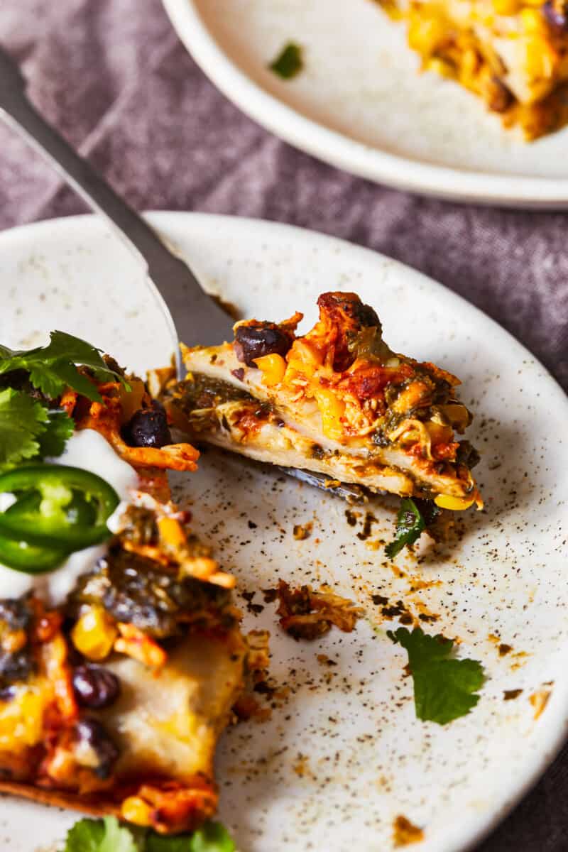 fork on a plate with a piece of mexican chicken lasagna