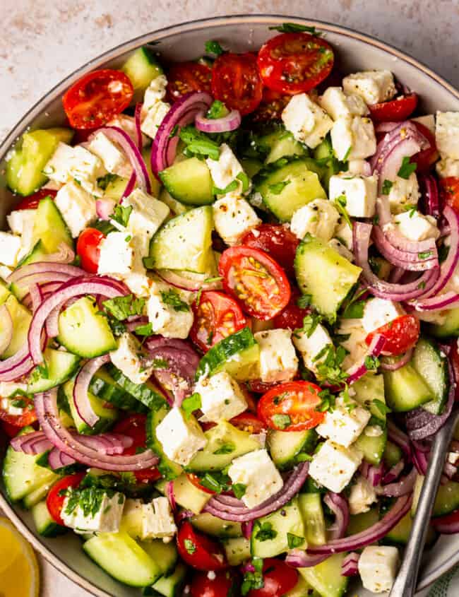 large bowl filled with a colorful cucumber tomato salad