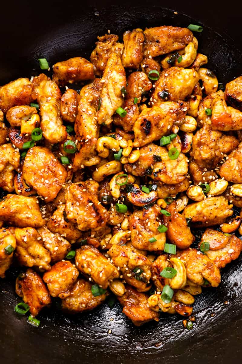 close up of cashew chicken in a cast iron wok.