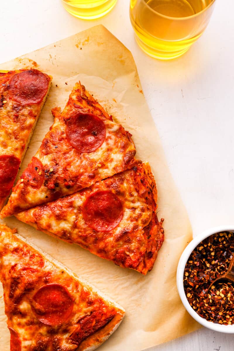 close up on half of a pepperoni pizza cut into slices