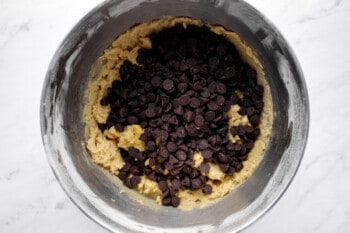 adding chocolate chips to cookie dough