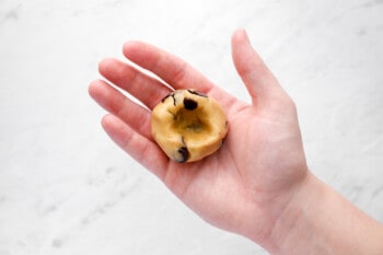 hand holding a ball of cookie dough