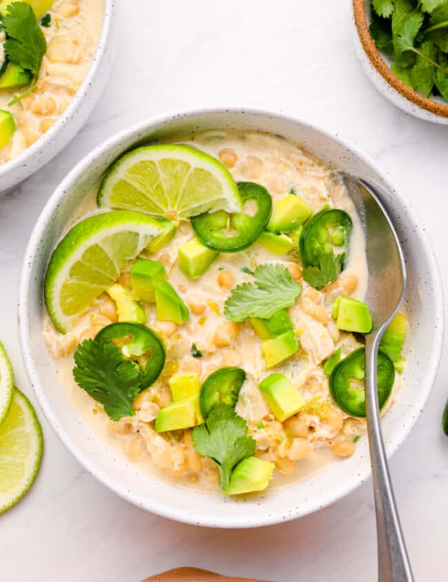 overhead view of instant pot white chicken chili in a white bowl with a spoon.