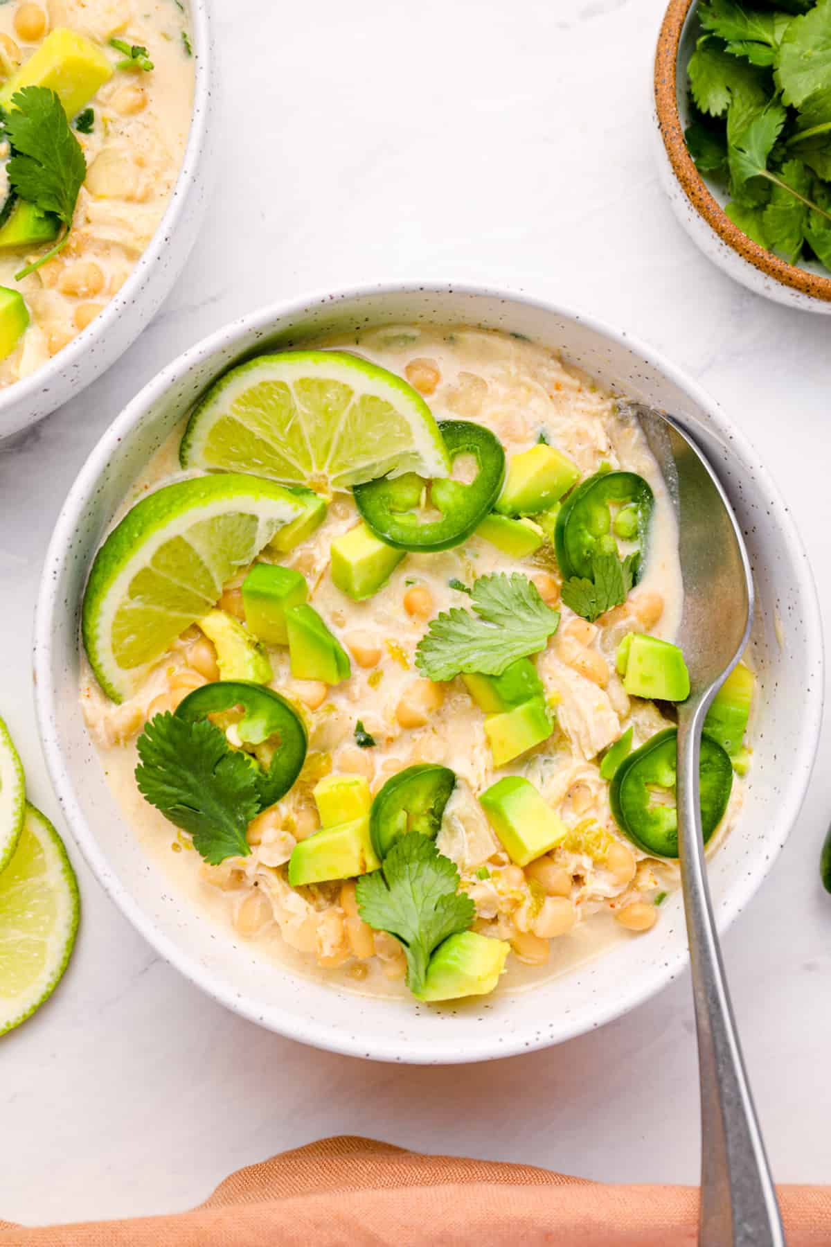 overhead view of instant pot white chicken chili in a white bowl with a spoon.