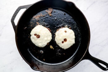 pan-frying burgers topped with Swiss cheese