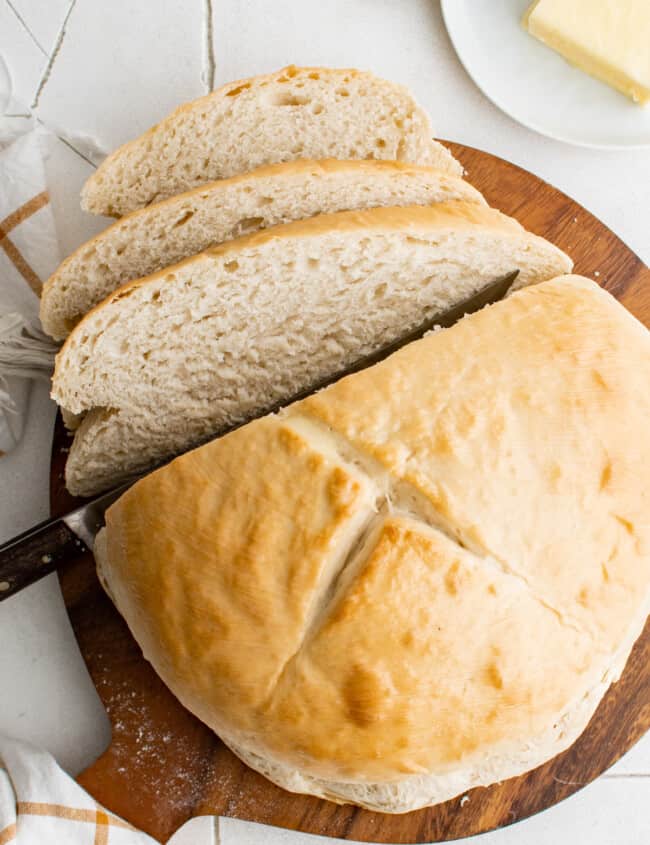 cutting a loaf of skillet bread into slices