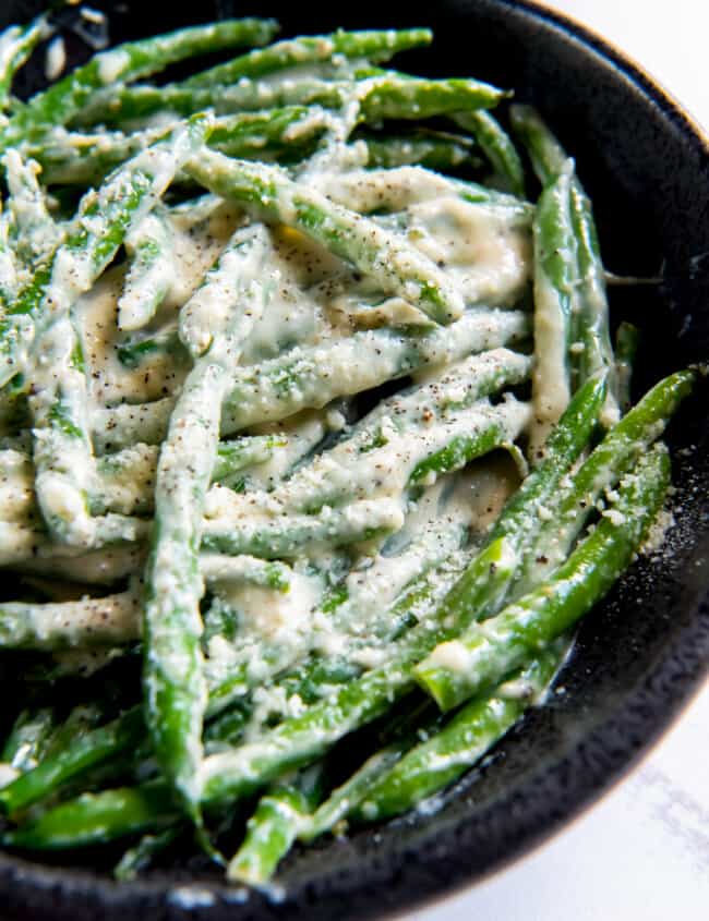 creamed green beans in a cast iron skillet.