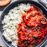 overhead view of crockpot chicken cacciatore with rice in a black bowl.