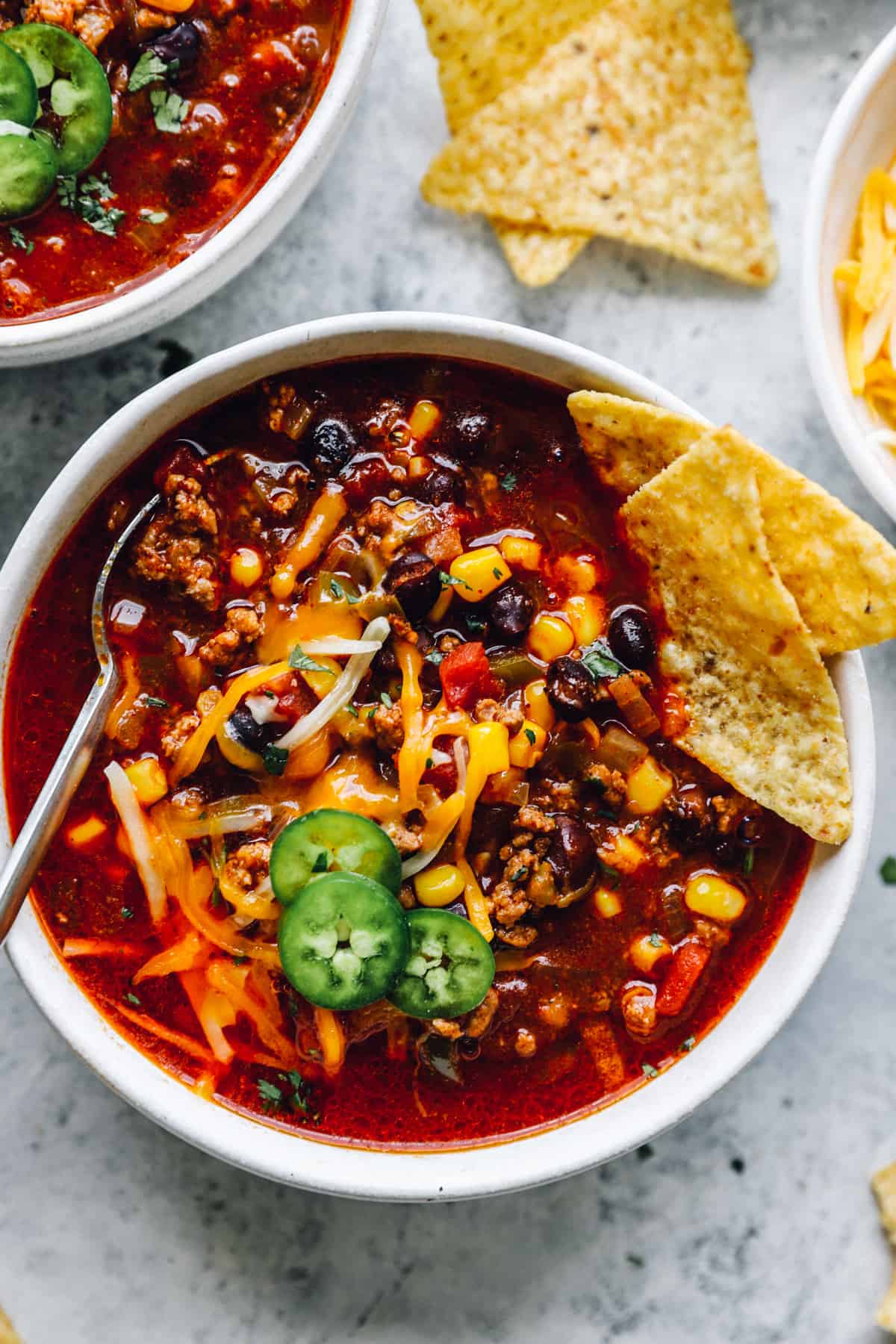 overhead view of crockpot taco soup in a white bowl with a spoon.