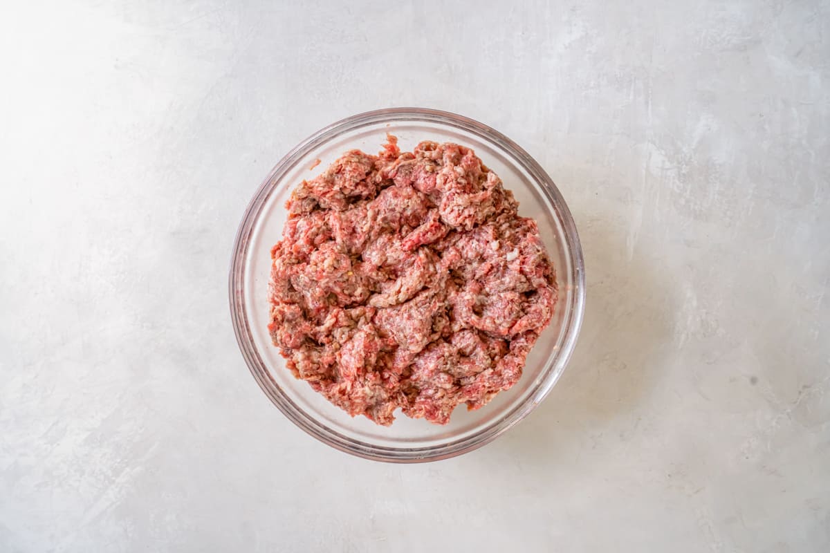 ground beef and breakfast sausage meat mixed together in a glass bowl.