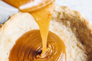 pouring caramel filling into the pie crust