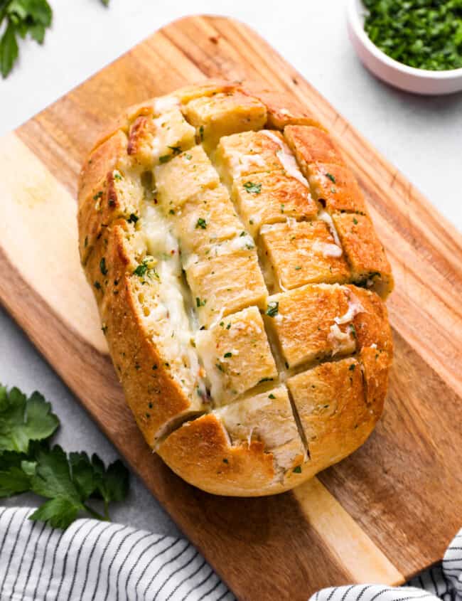 pull apart cheese bread on a wooden cutting board.