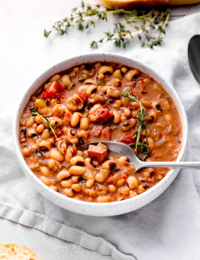 crockpot black eyed peas in a white bowl with a spoon.