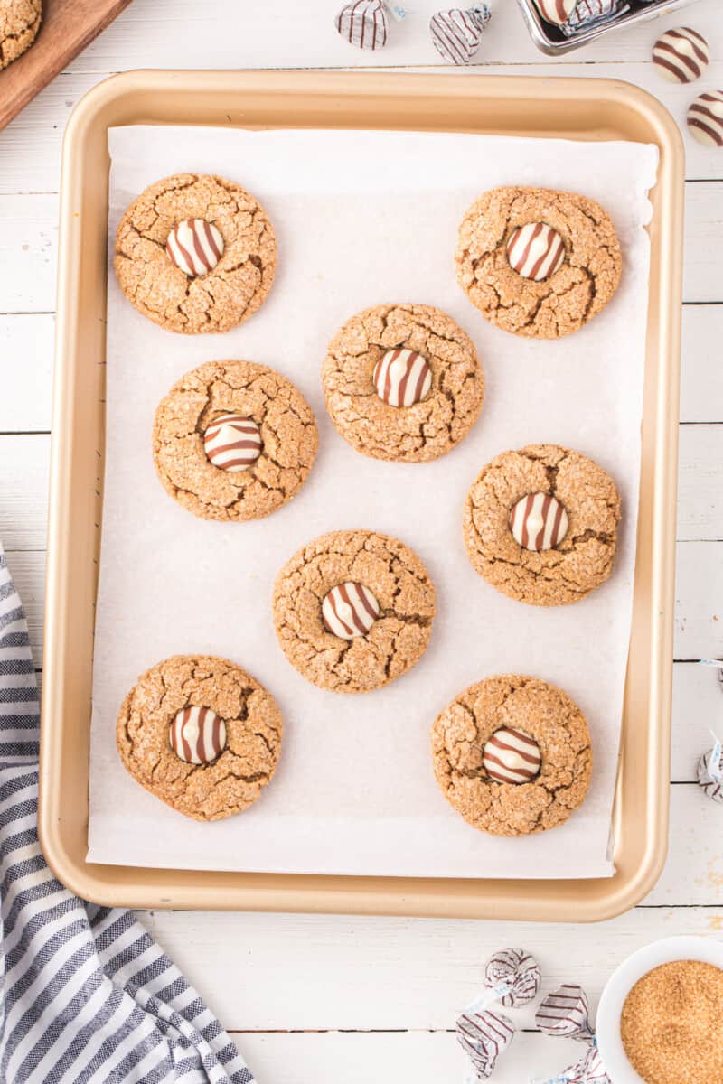 gingerbread kiss cookies on a parchment-lined baking tray