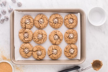 gingerbread kiss cookies lined up on a. baking sheet