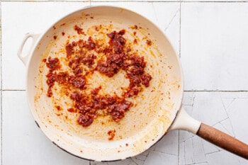 a frying pan filled with a mixture of meat and spices.