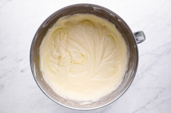 whipped cream in a bowl on a marble countertop.