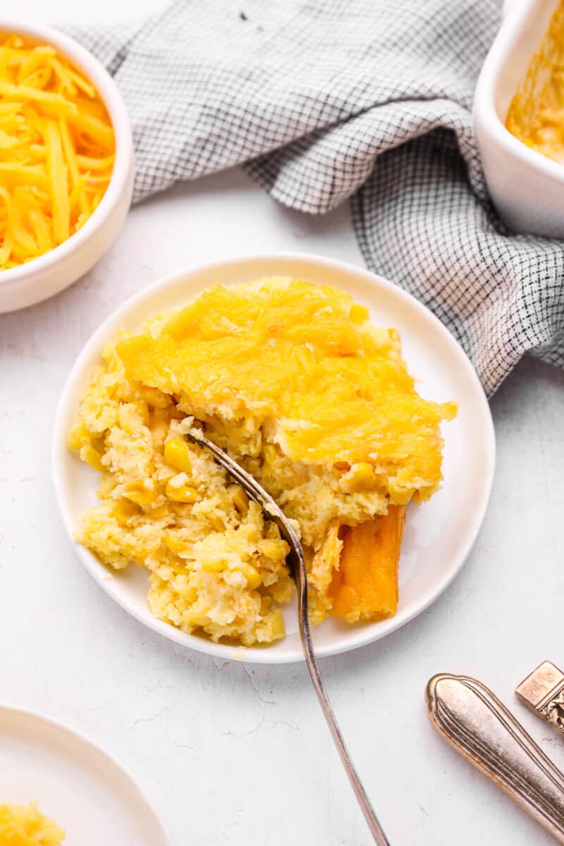 corn casserole on a white plate with a fork.