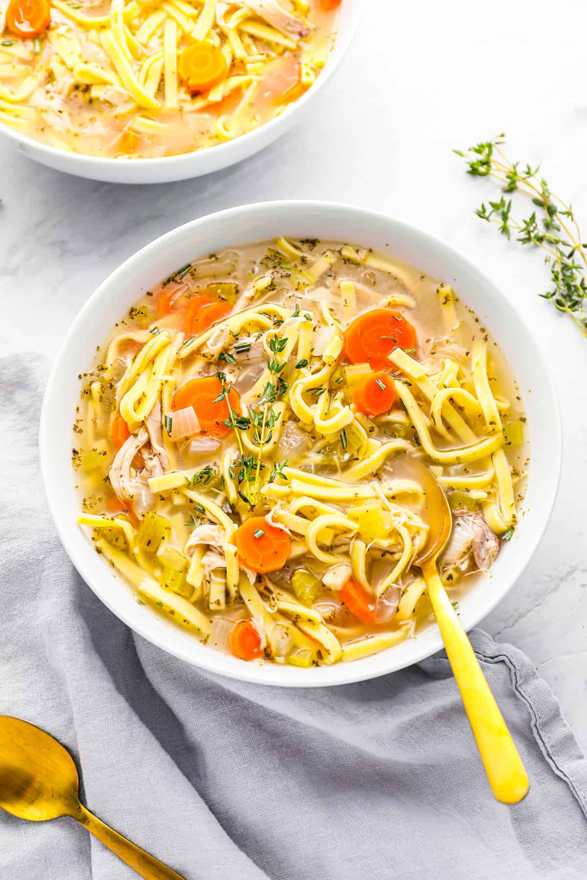 crockpot turkey noodle soup in a white bowl with a spoon