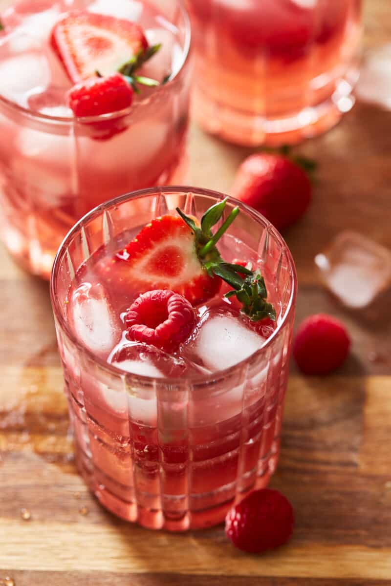 glass of red berry sangria with raspberries and strawberries as garnish