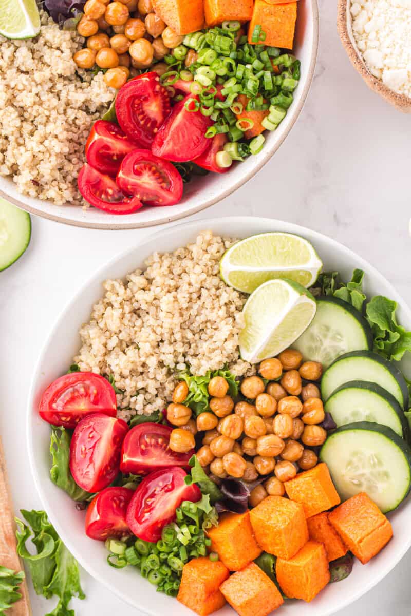 overhead view of 2 assembled buddha bowls without dressing in white bowls.