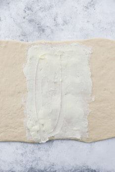 buttered cronut dough on a marble counter.