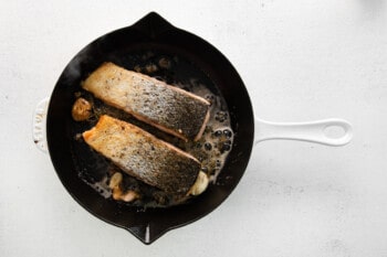 2 partially cooked salmon filets skin side up in a cast iron skillet.