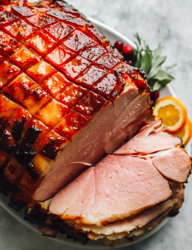 sliced brown sugar glazed ham on a platter.