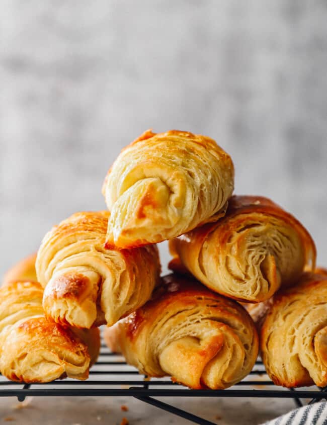 a pyramid of 6 croissants on a wire rack.