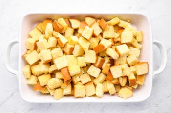 cubed bread in a white baking pan.