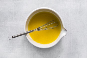 butter in a white bowl with a whisk.