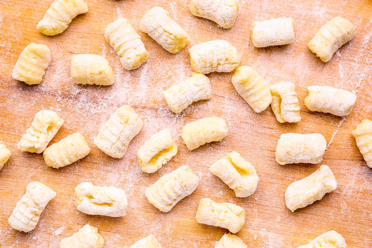 shaped gnocchi on a wooden cutting board.