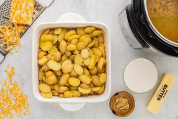 sliced potatoes in a white square baking dish.