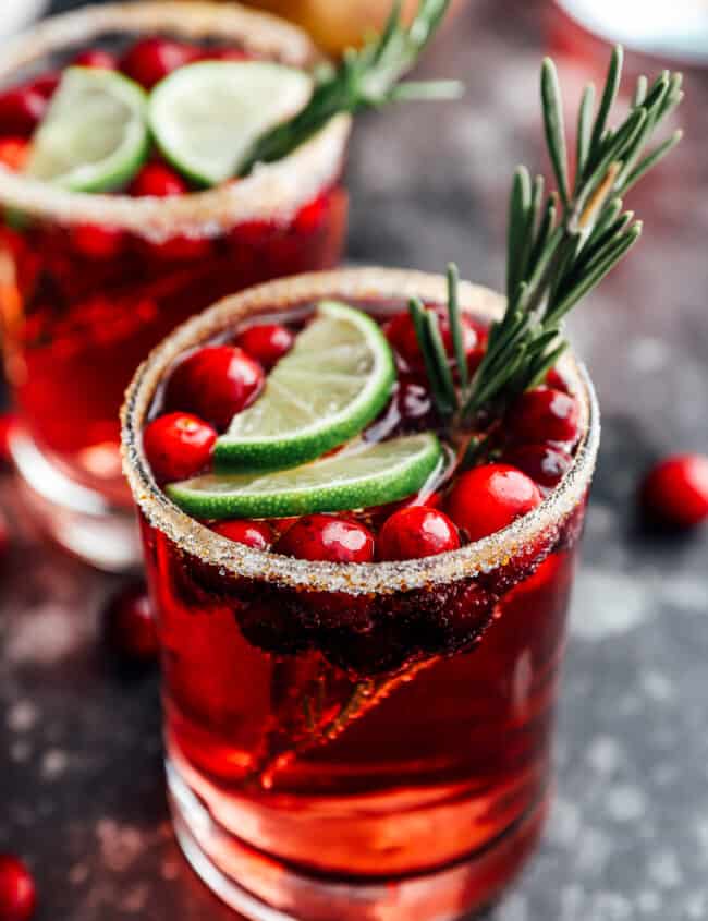 2 glasses of jingle juice garnished with lime slices and rosemary.