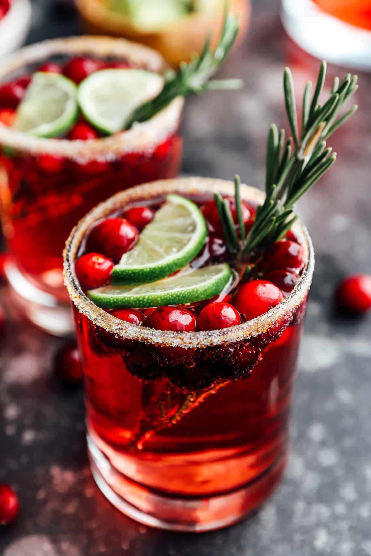 2 glasses of jingle juice garnished with lime slices and rosemary.