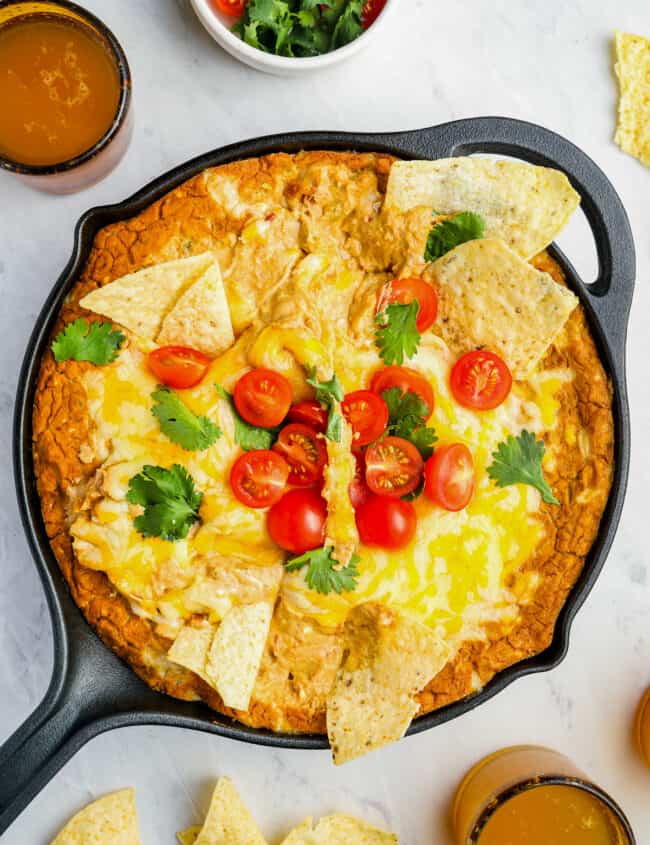 overhead view of cheesy bean dip in a cast iron skillet with the handle pointing to the left.