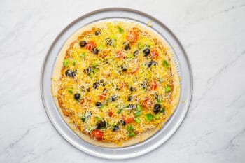 unbaked taco pizza on a pizza pan.